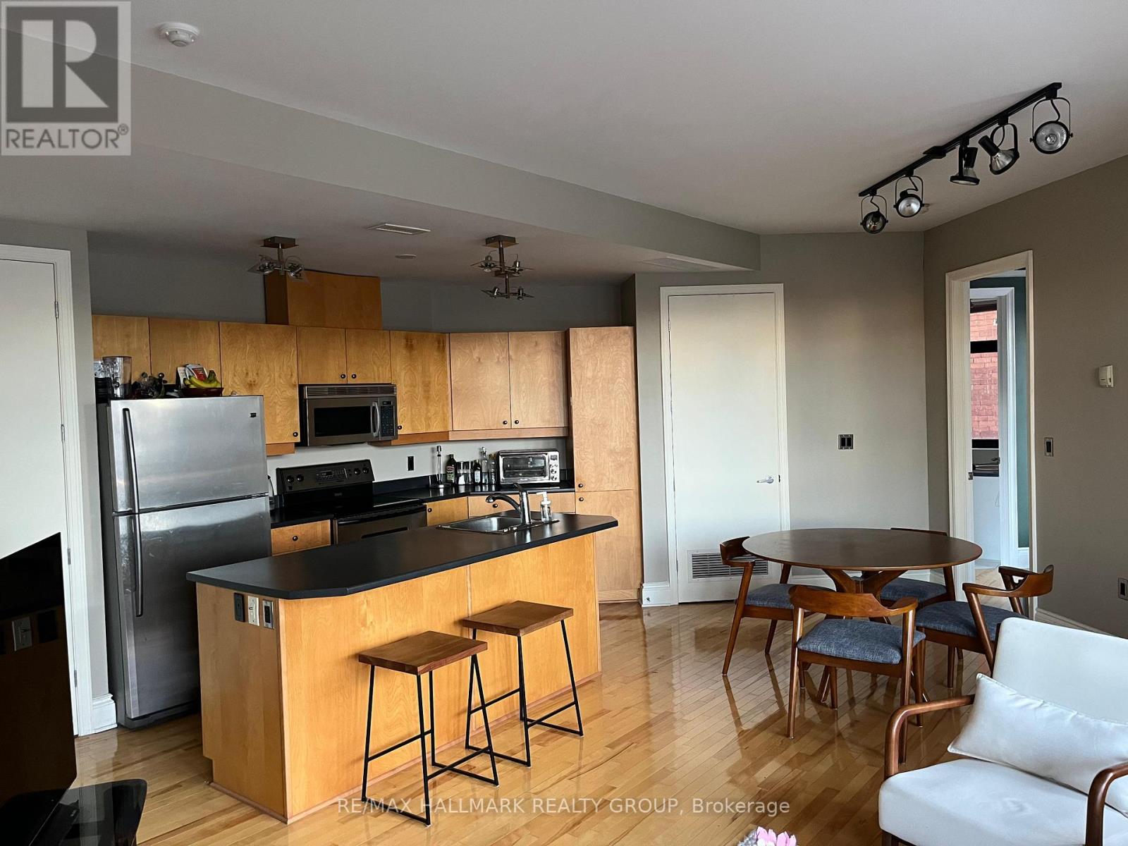 A kitchen with a bar stool and a dining table.