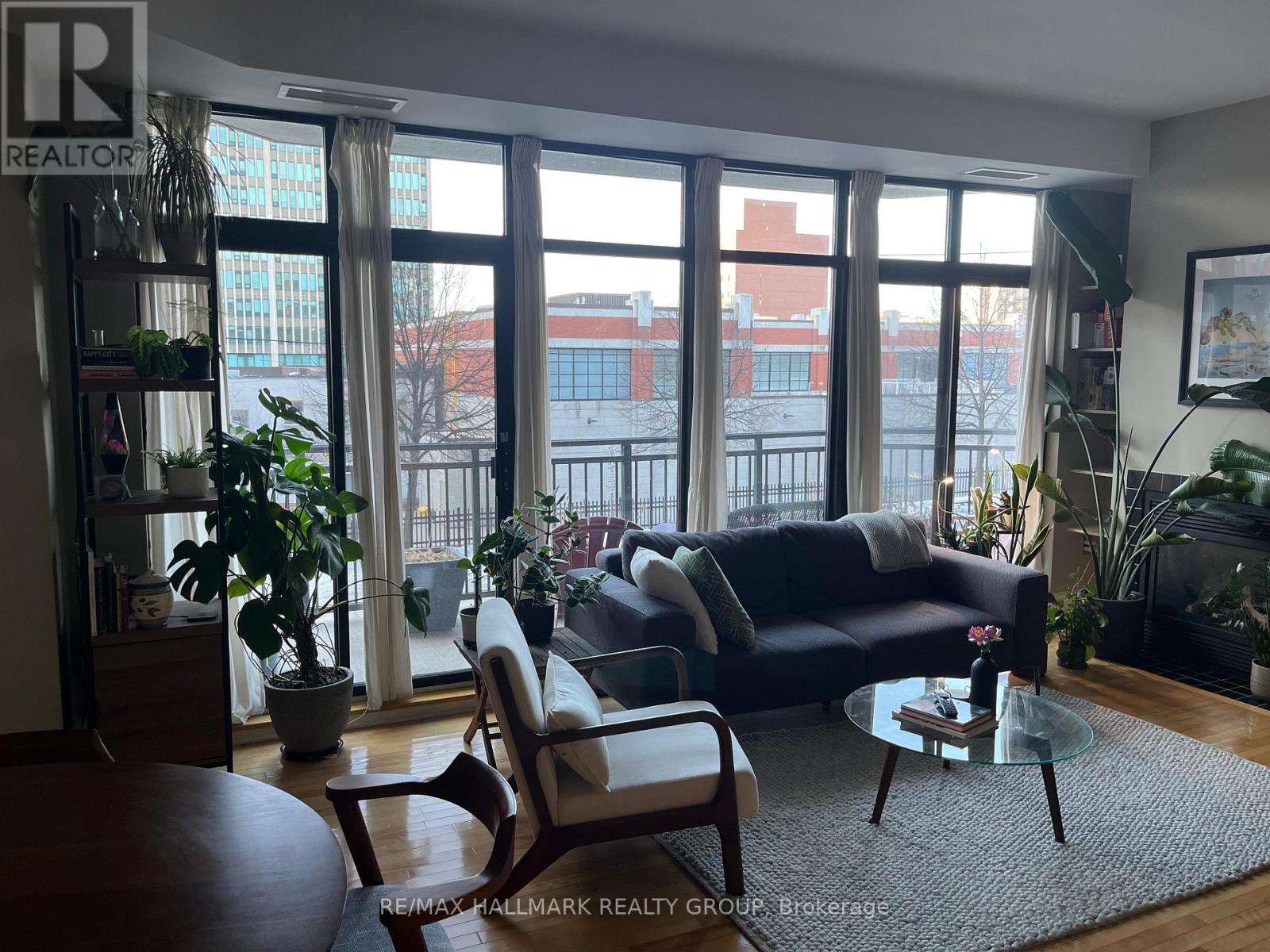 A living room with a couch, chair, and potted plants.