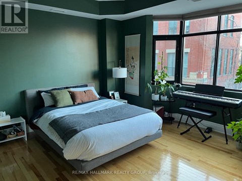 A bedroom with a large bed and a piano.