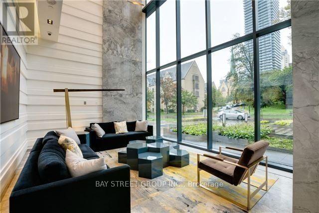 A living room with a black couch and a brown chair.