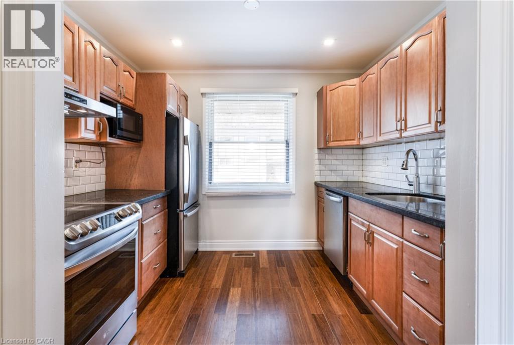 A kitchen with wooden cabinets and black countertops.
