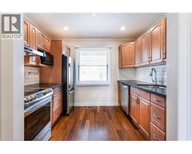 A kitchen with wooden cabinets and black countertops.