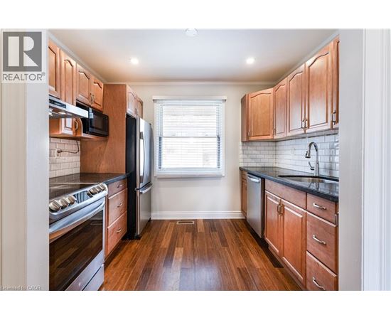 A kitchen with wooden cabinets and black countertops.