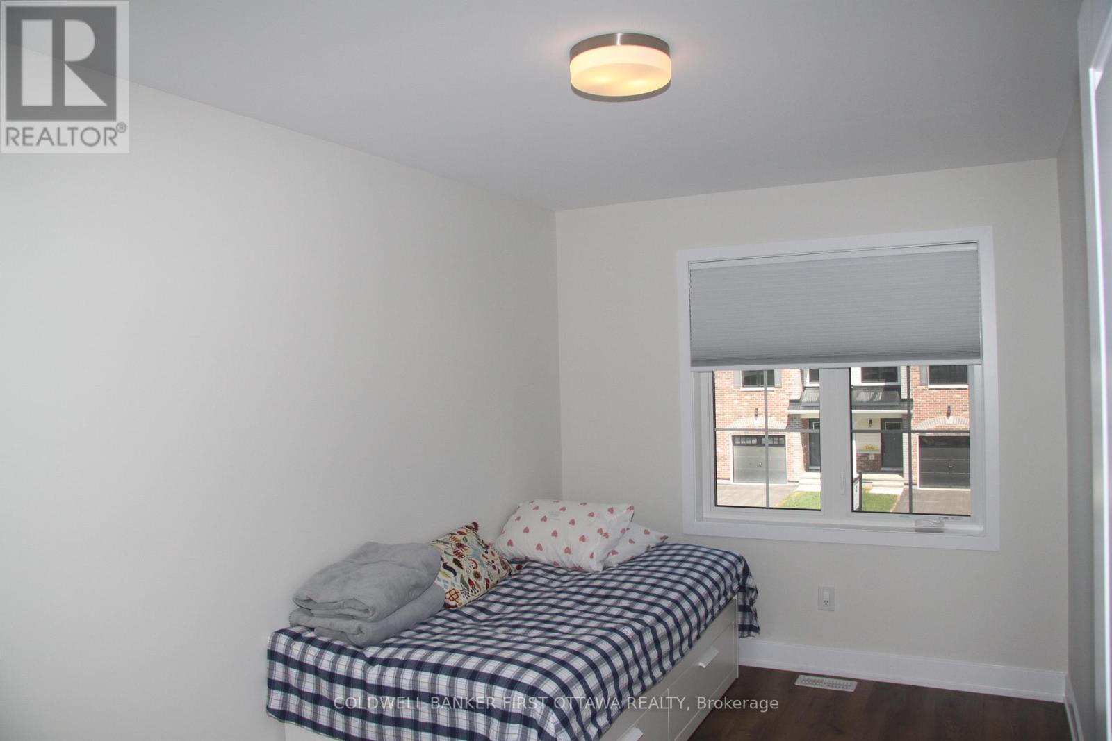 A bedroom with a bed and a window.