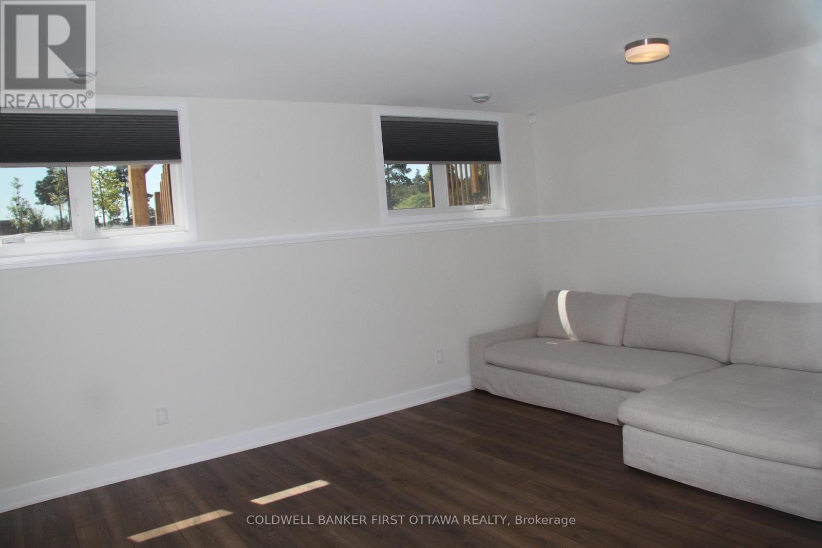 A living room with a couch and a window.
