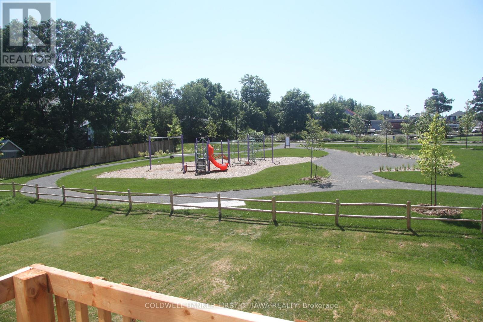 A playground with a slide and a wooden fence.