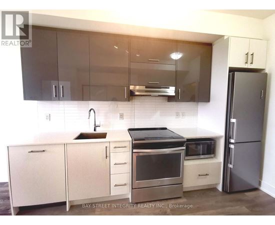 A modern kitchen with a stainless steel refrigerator and white cabinets.