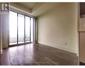 A room with a sliding glass door and wooden flooring.