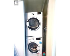 A stacked washer and dryer in a small space.