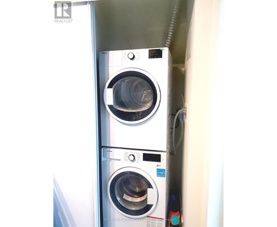 A stacked washer and dryer in a small space.