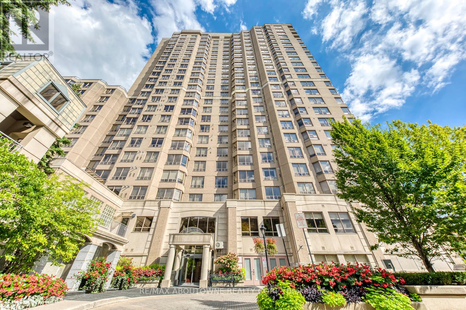A tall building with a lot of windows and a green lawn in front.