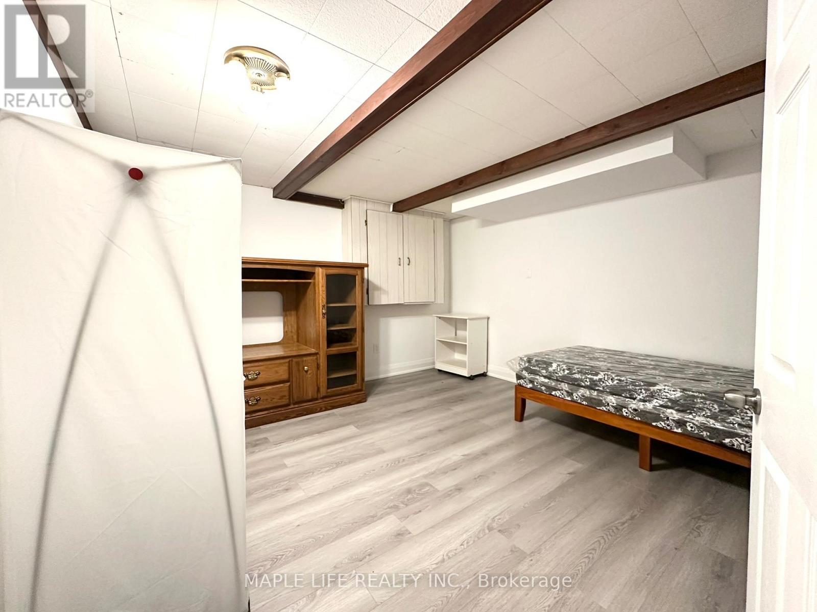 A bedroom with a bed, dresser, and wardrobe.