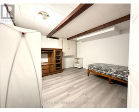 A bedroom with a bed, dresser, and wardrobe.