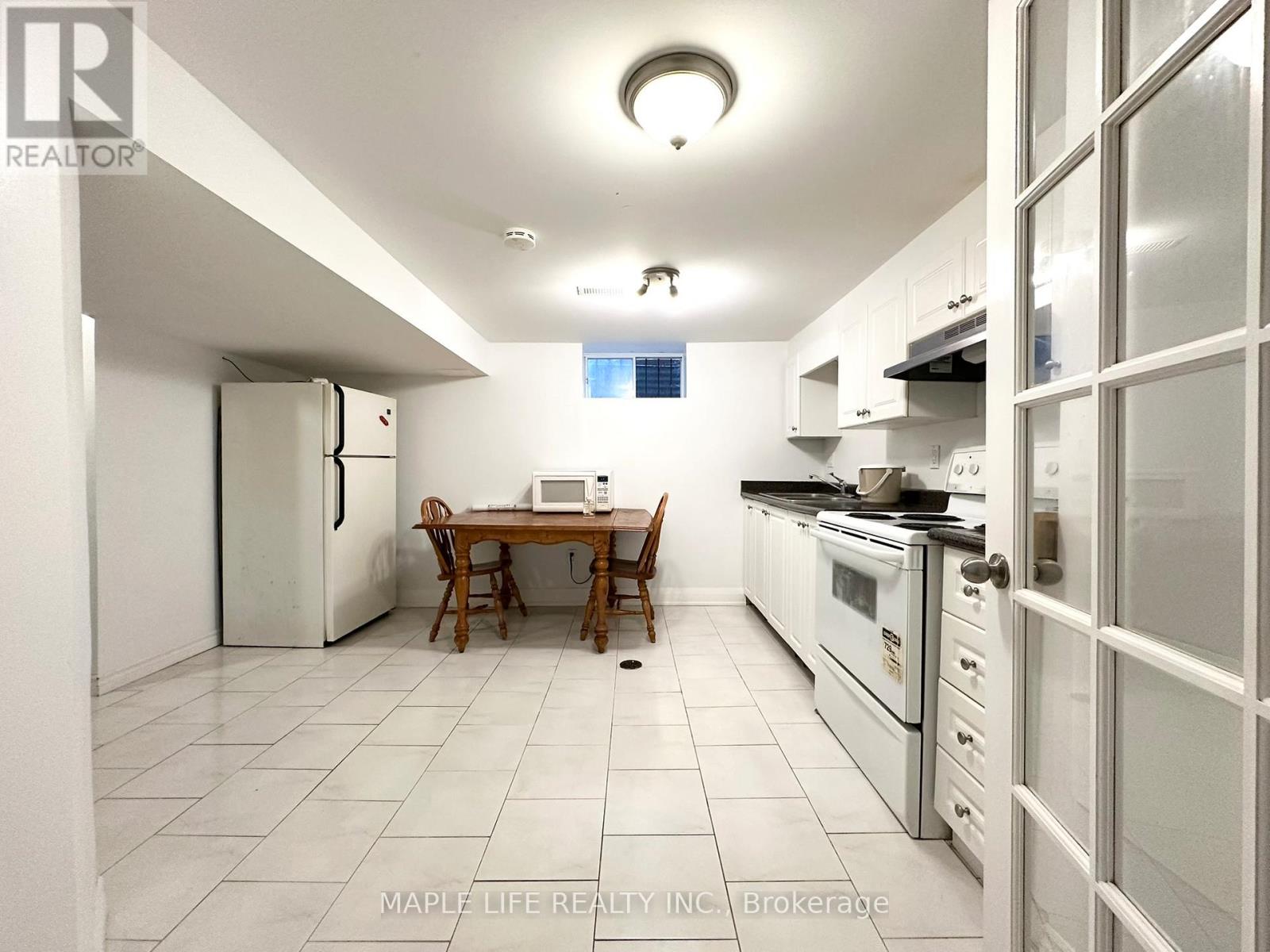 A kitchen with a table and chairs in the middle of it.