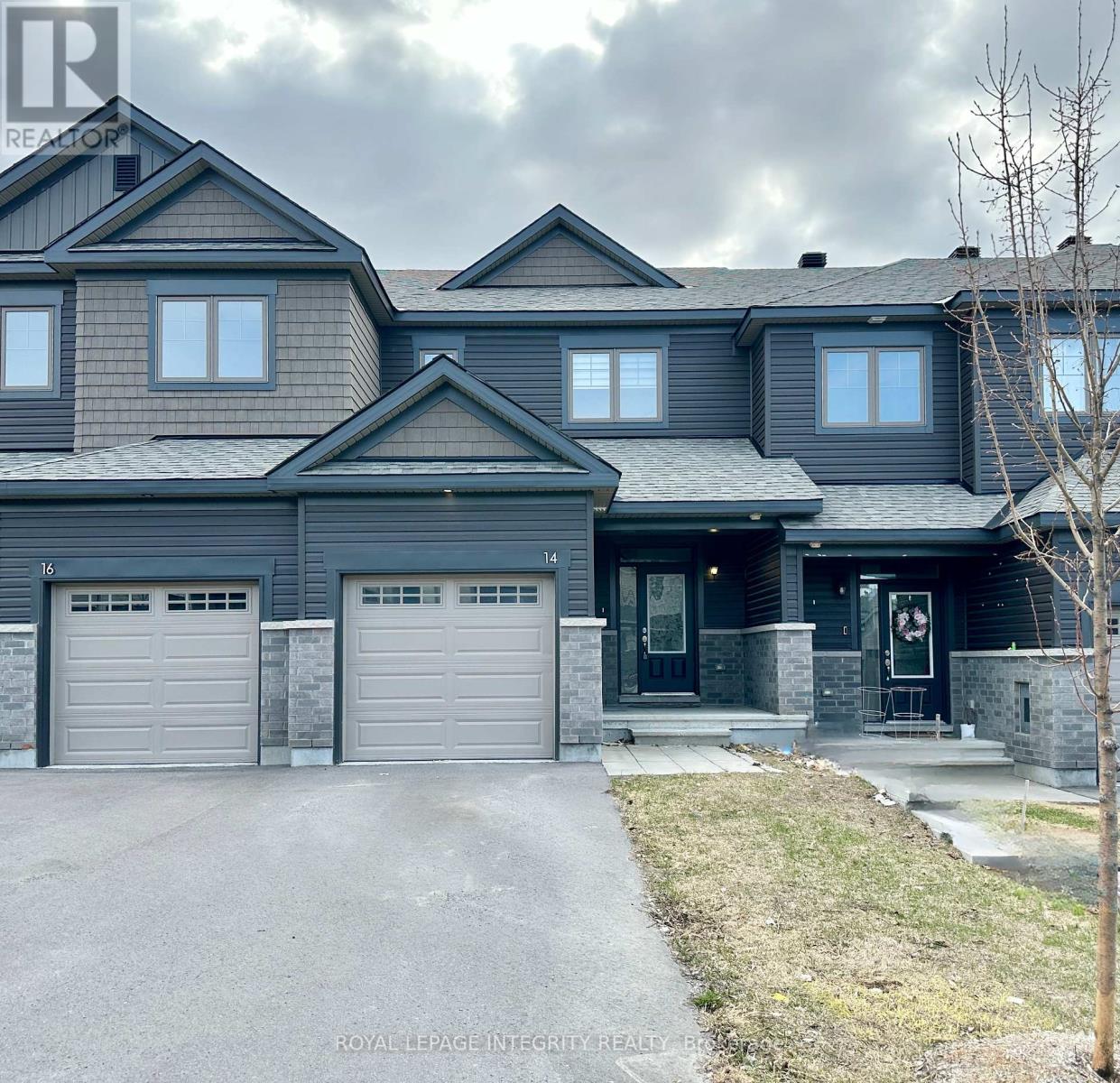 A large, modern house with a grey garage door and a black front door.