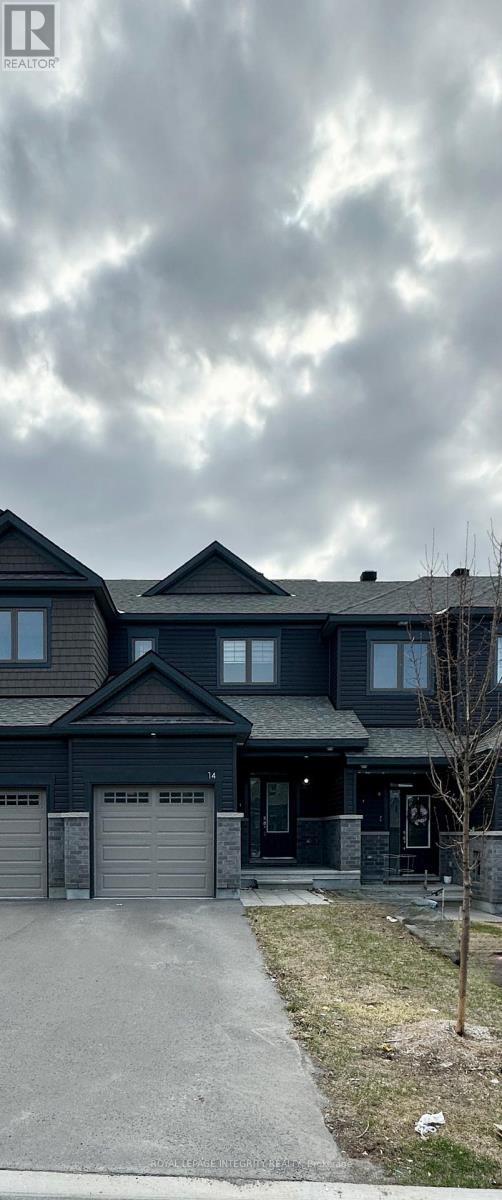 A large house with a grey garage door and a driveway.