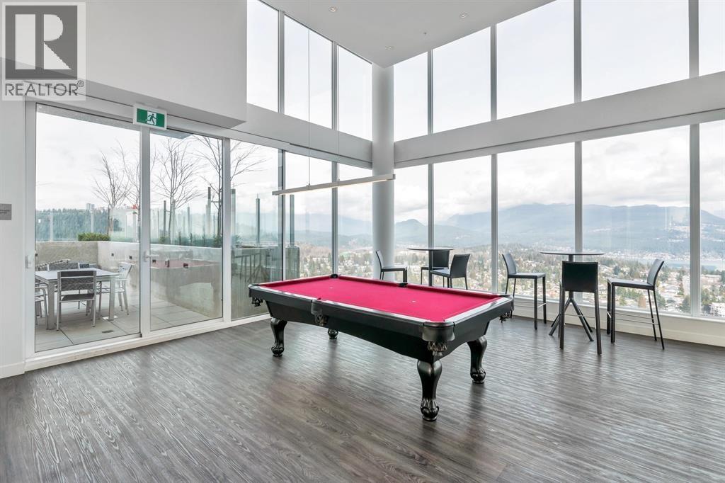 A pool table in a room with a view of the city.