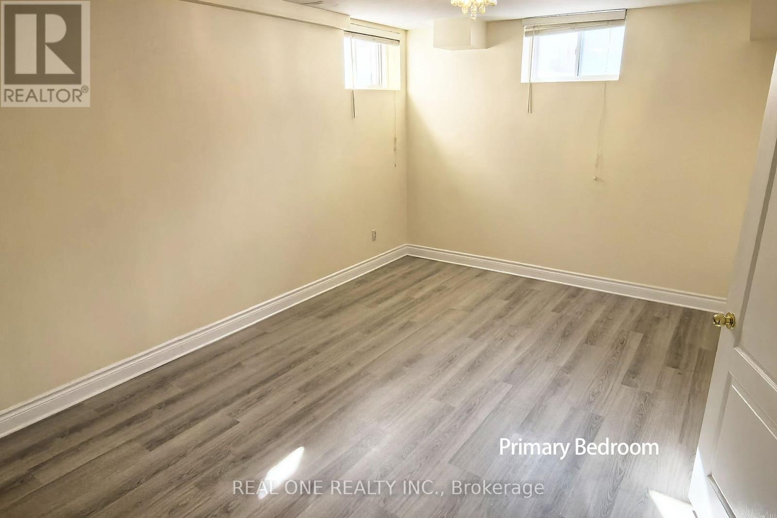 A room with wooden flooring and a window is labeled as the primary bedroom.
