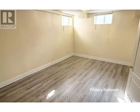 A room with wooden flooring and a window is labeled as the primary bedroom.
