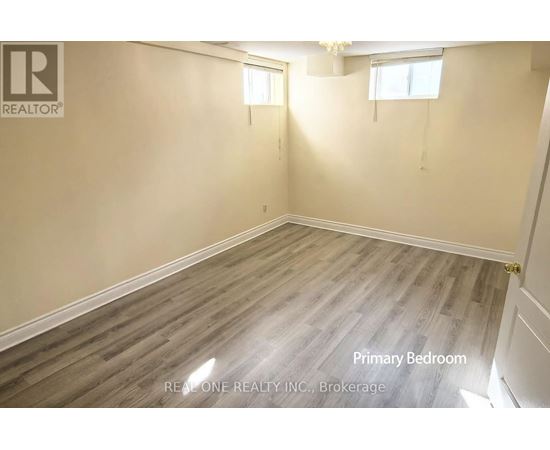 A room with wooden flooring and a window is labeled as the primary bedroom.