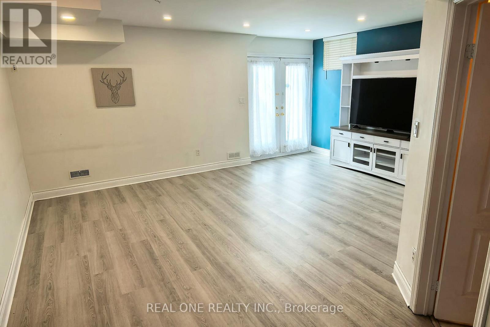 A spacious living room with a television and a flat screen window.