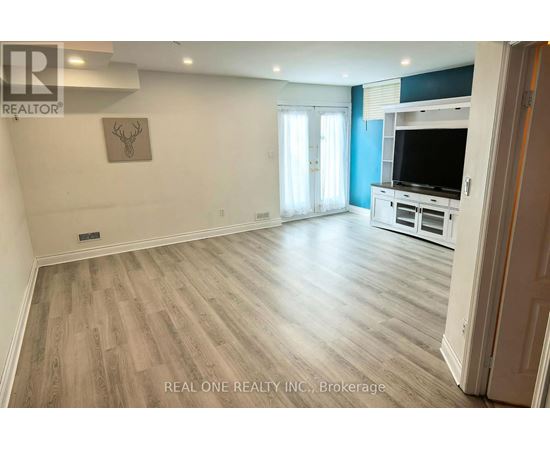 A spacious living room with a television and a flat screen window.