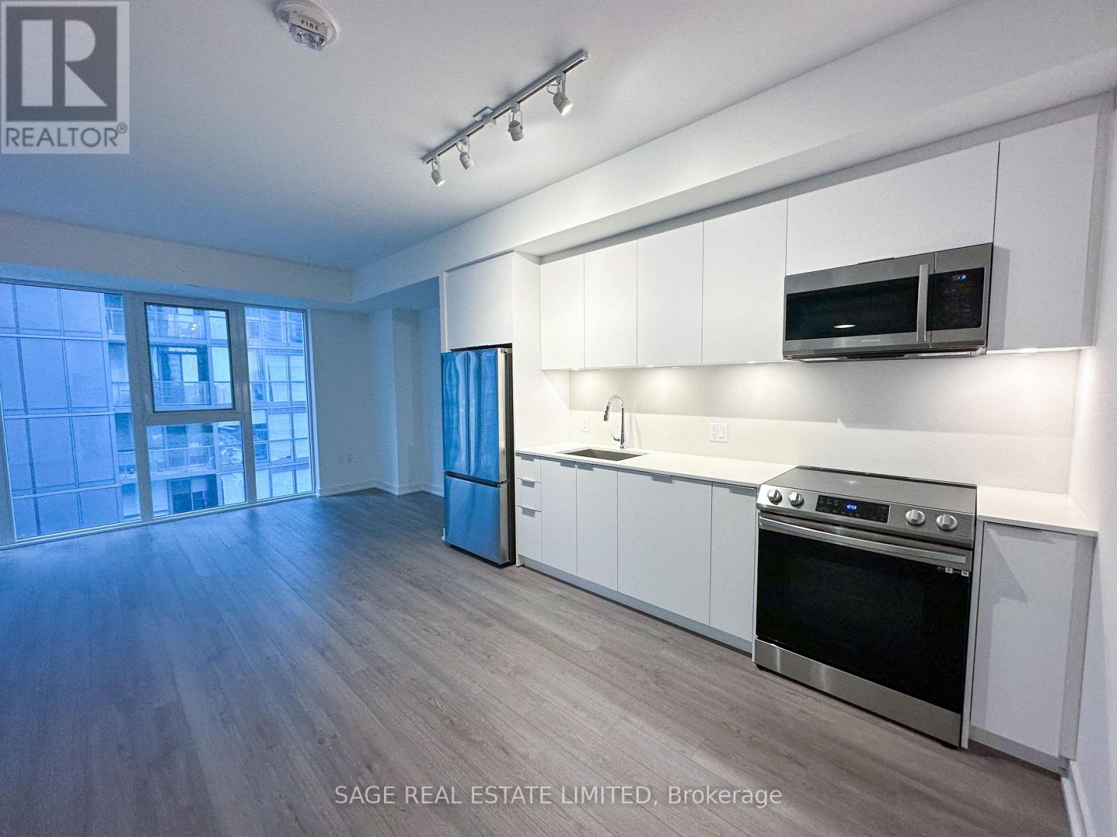 A well-lit kitchen with white cabinets and stainless steel appliances.