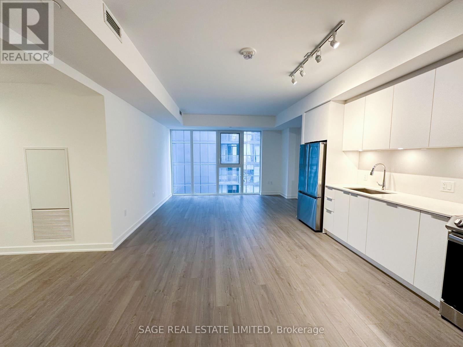 A spacious living area with a kitchenette and a view of a window.
