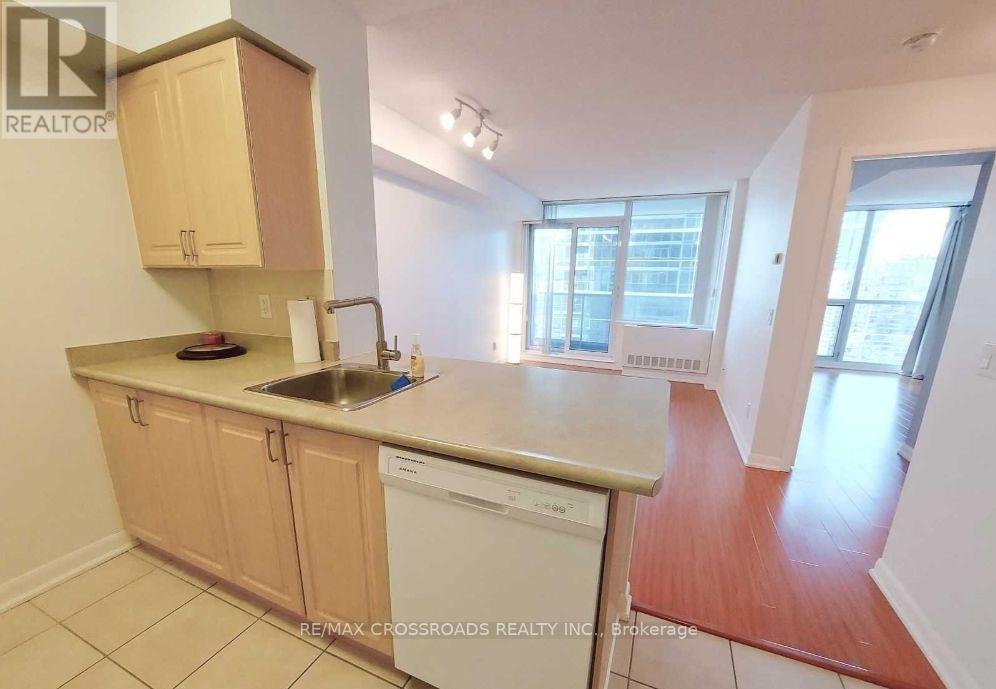 A kitchen with a sink, dishwasher and cabinets.