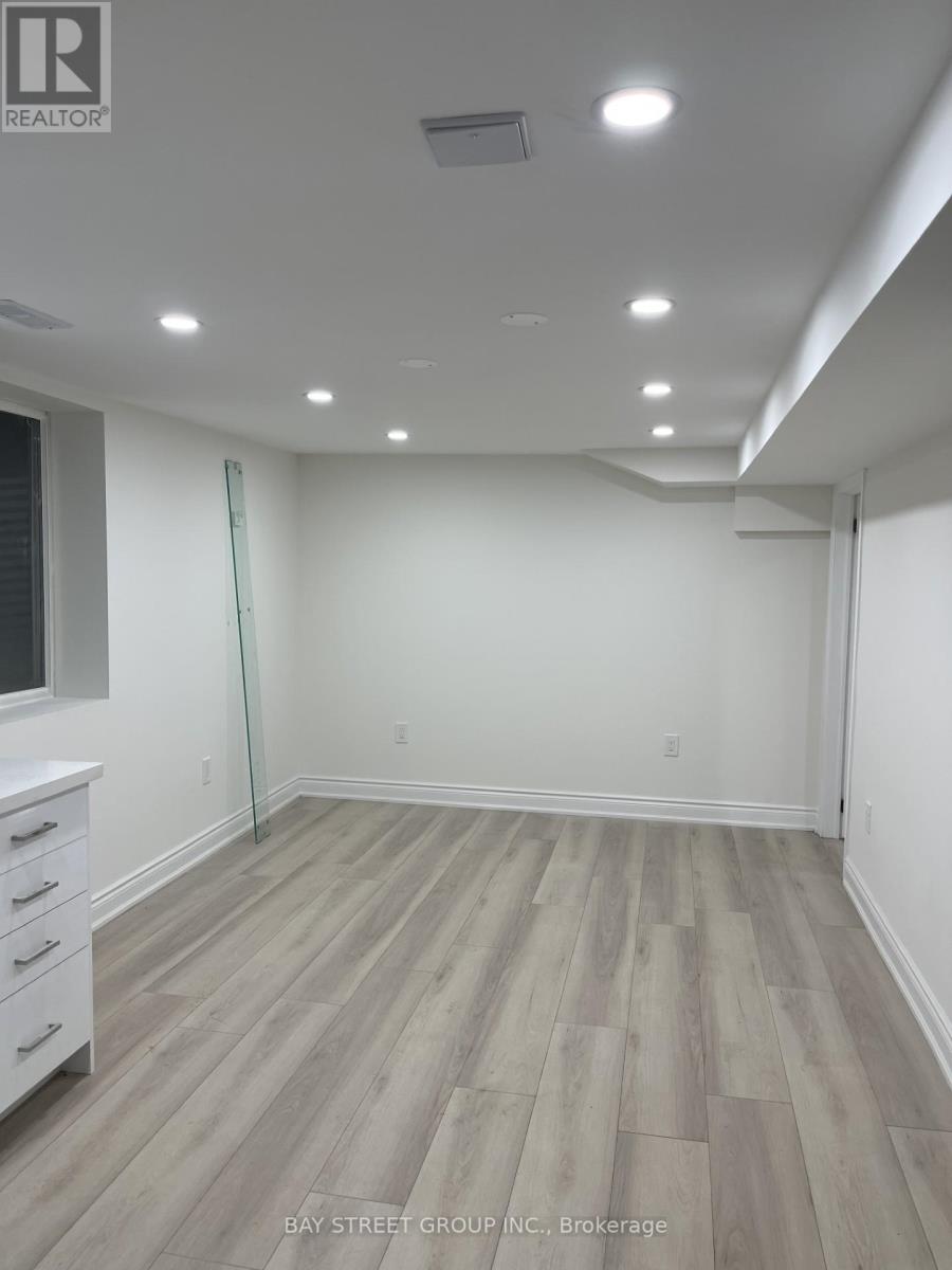 A room with white walls and wooden flooring with a glass door.