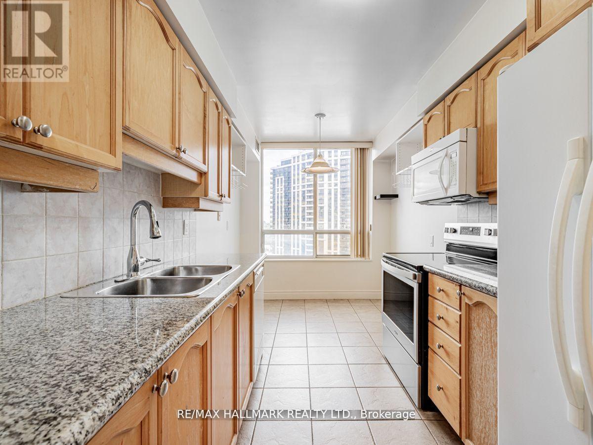 A kitchen with wooden cabinets and a granite countertop.