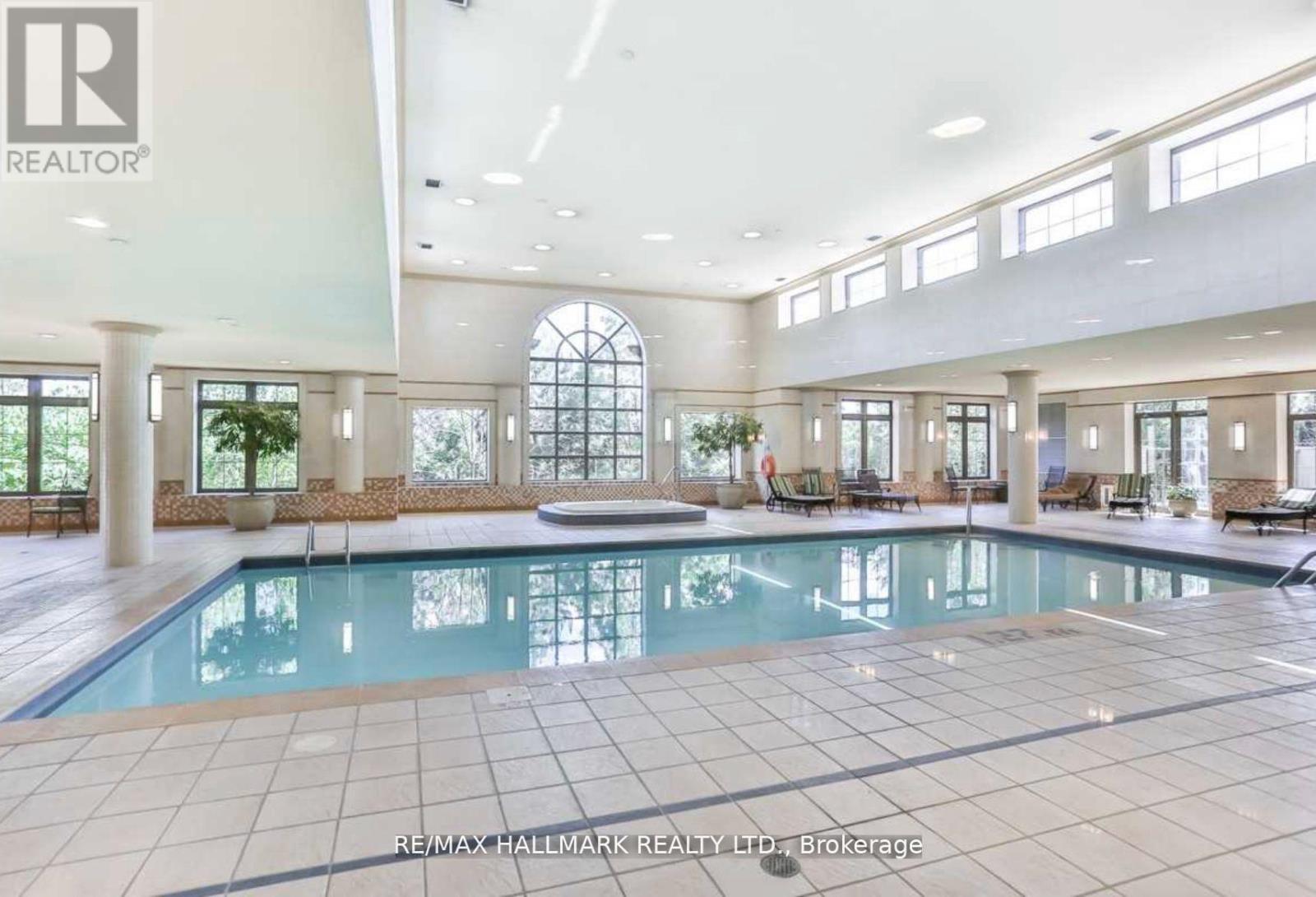 A large indoor swimming pool in a spacious room.