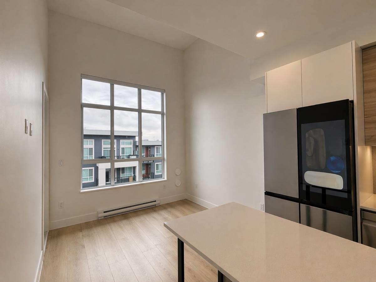 A kitchen with a large window overlooking a building.