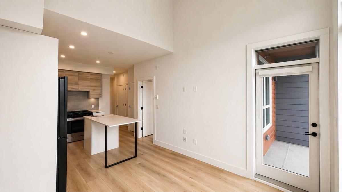 A white room with a table and a door leading to a balcony.