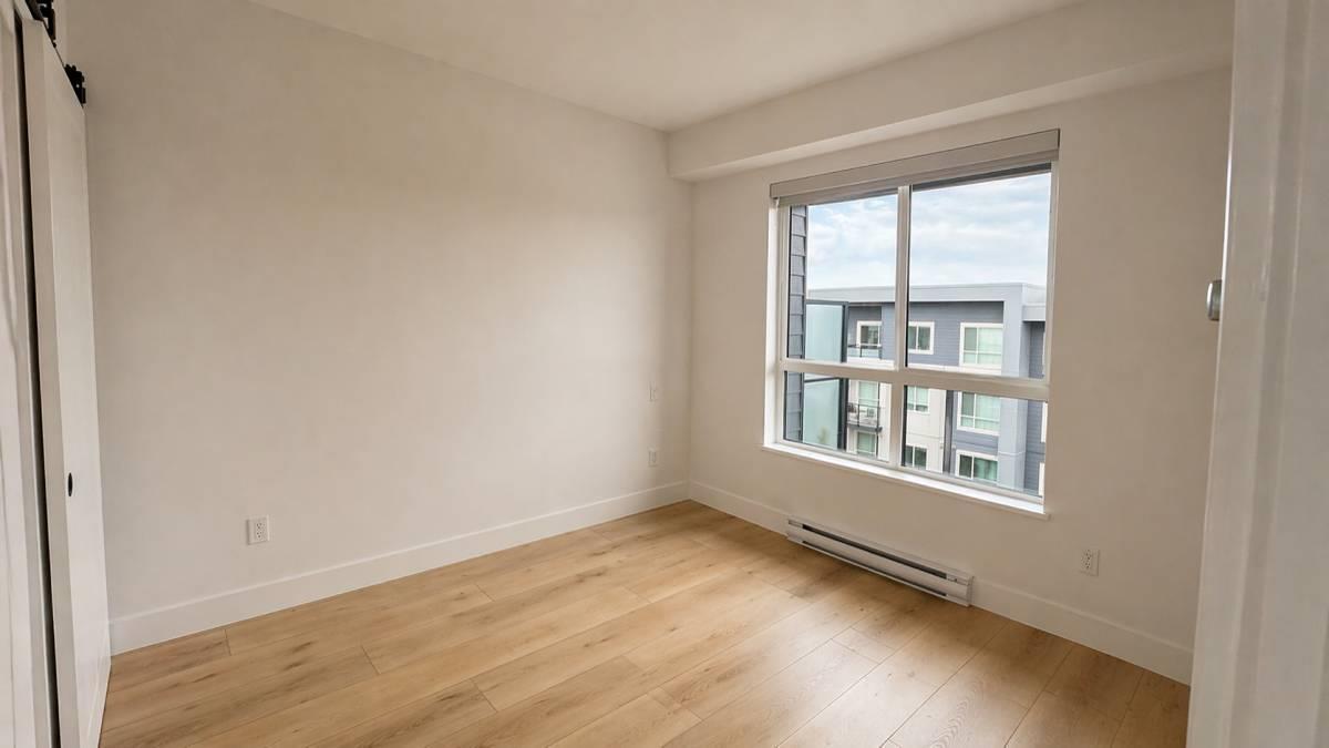 Empty room with a window overlooking a building.