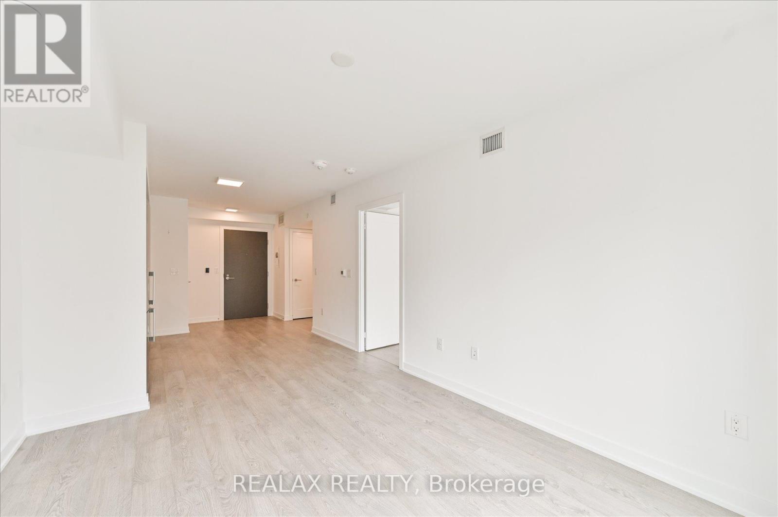 A spacious, empty room with a doorway leading to another room.