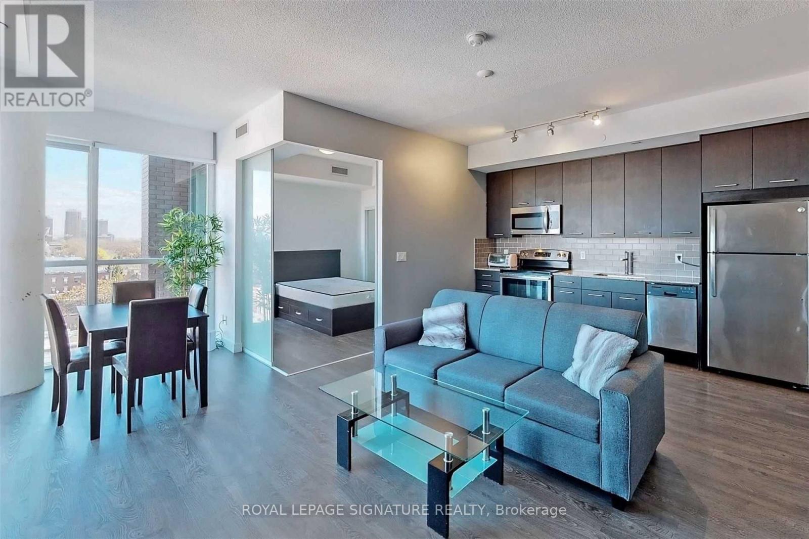A modern living room with a grey couch and a glass coffee table.