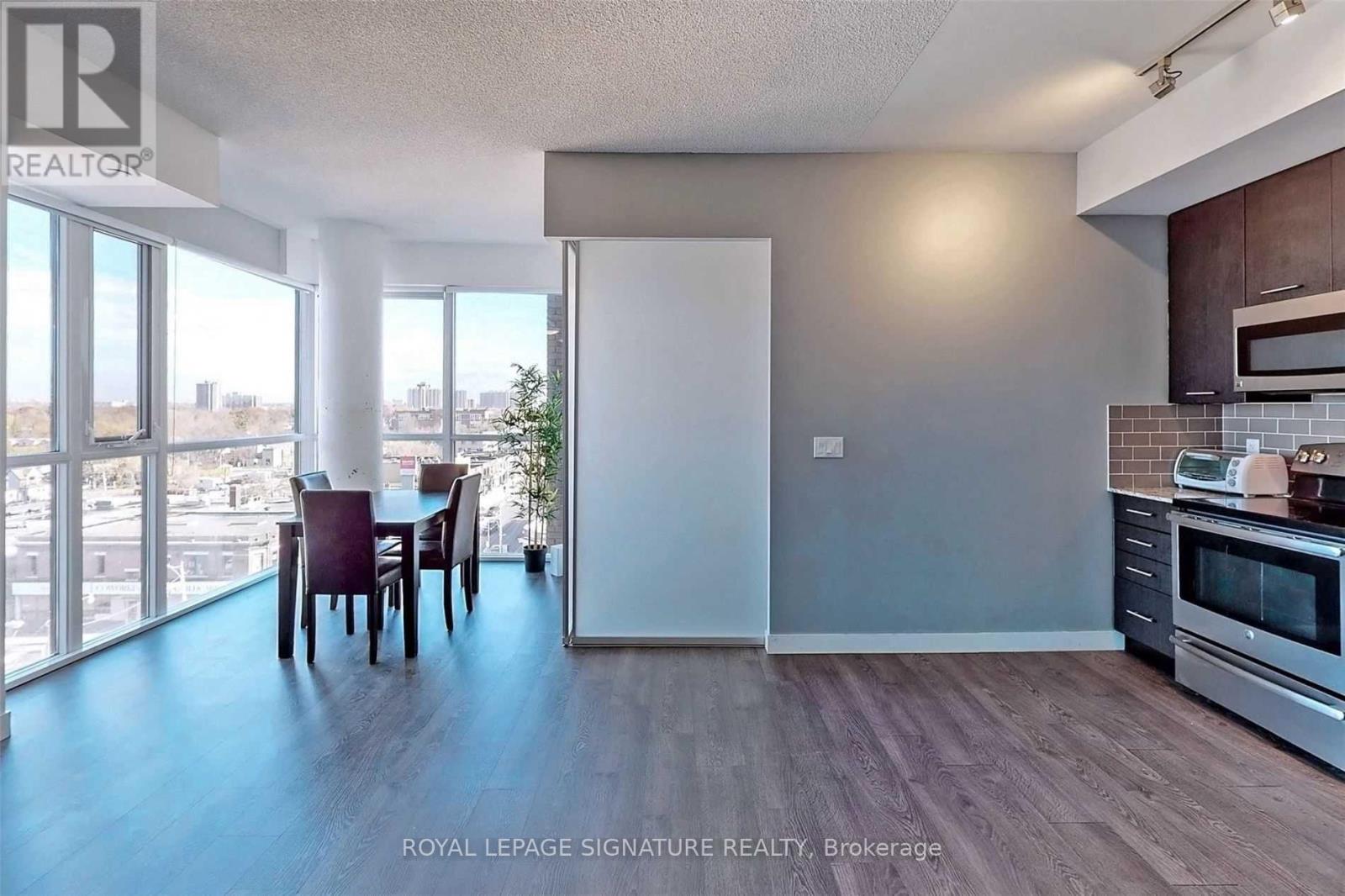 A kitchen with a dining table and chairs in a room with a view of the outside.