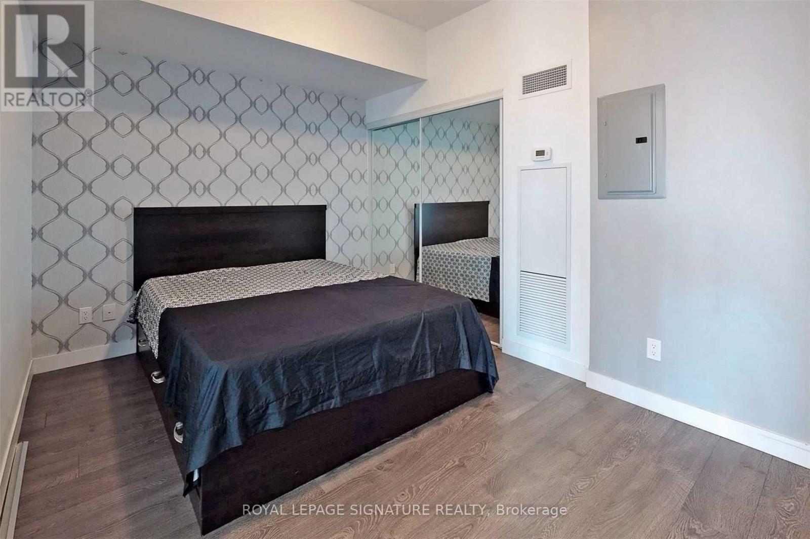 A bedroom with a bed and a wallpapered wall.