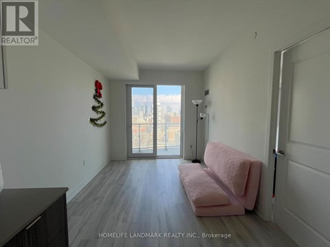A living room with a pink couch and a wreath on the wall.