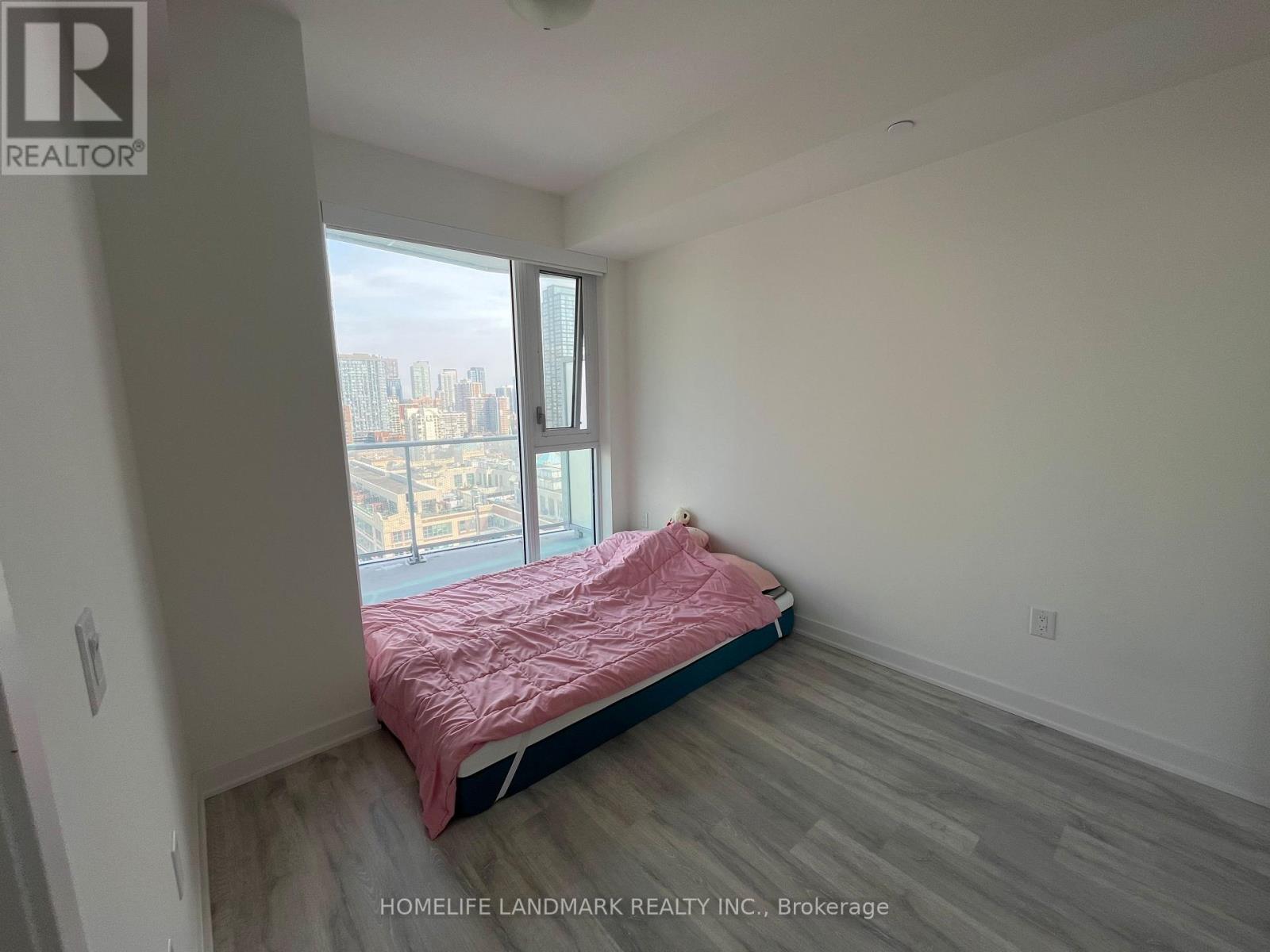 A bedroom with a large bed and a view of the city.