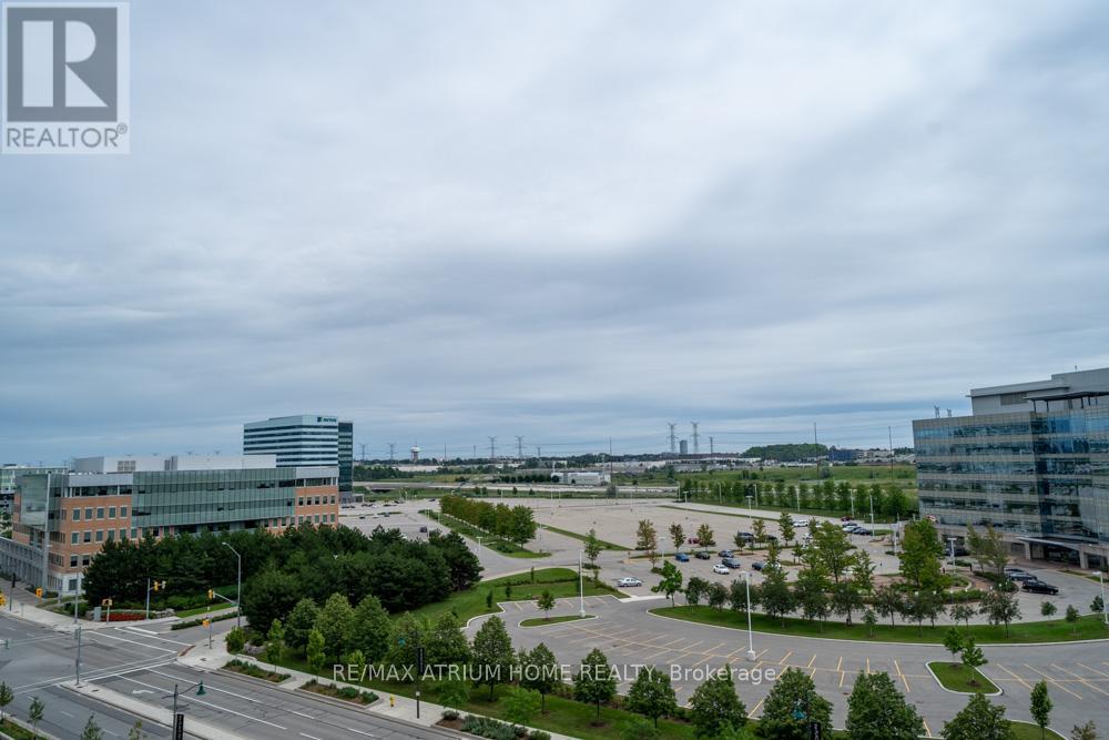 A view of a parking lot with a building in the background and a sign that says RE/MAX Atrium Home Realty Brokerage.
