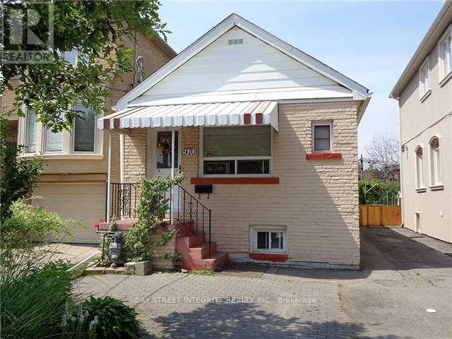 A house with a white roof and a red awning is for sale.