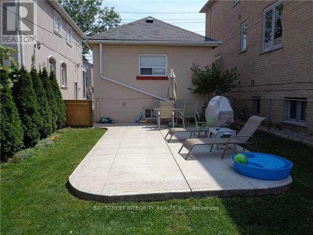 A backyard with a patio, lawn, and a pool table.