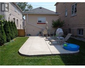 A backyard with a patio, lawn, and a pool table.