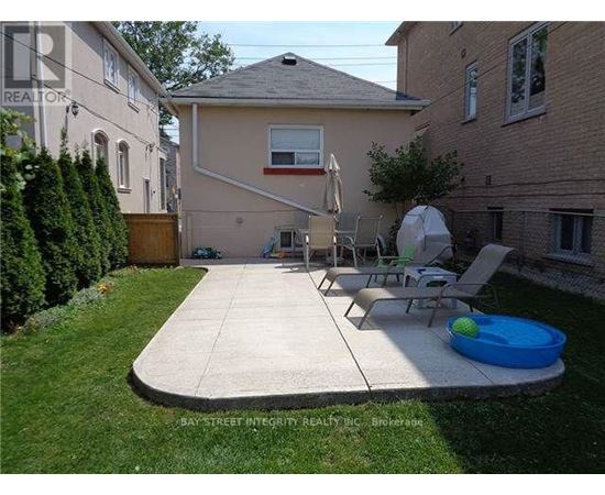 A backyard with a patio, lawn, and a pool table.