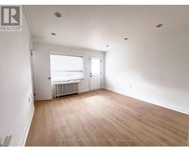 A room with a window and a door is empty and waiting to be furnished.