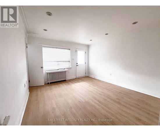 A room with a window and a door is empty and waiting to be furnished.
