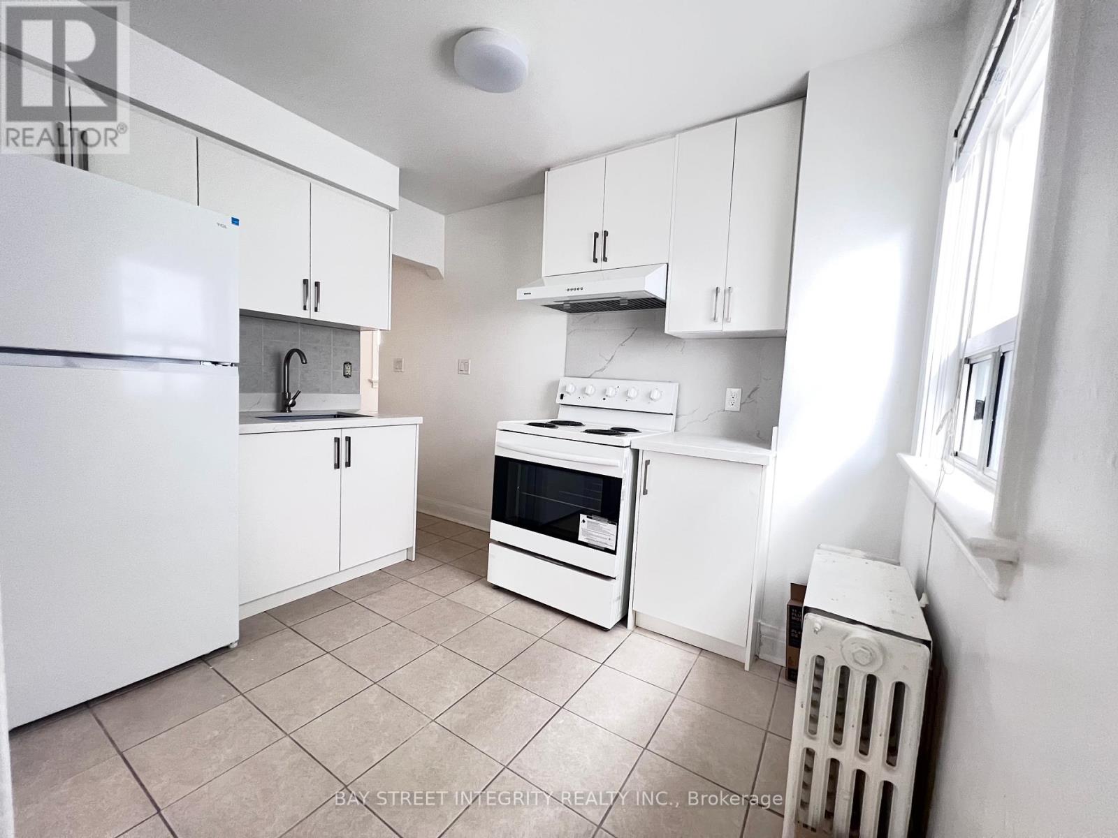 A small kitchen with white appliances and cabinets.
