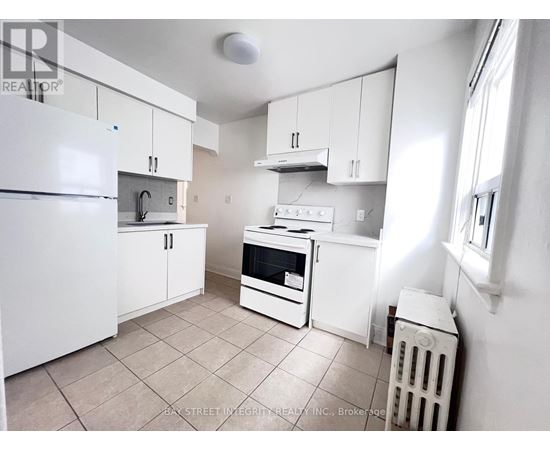 A small kitchen with white appliances and cabinets.